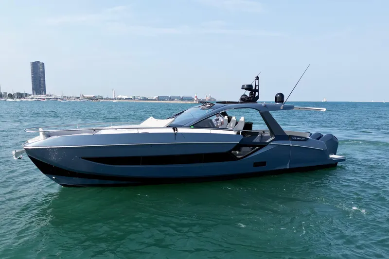  Yacht Photos Pics 2024 Azimut Verve 48 yacht cruising on open water, with city skyline in background.