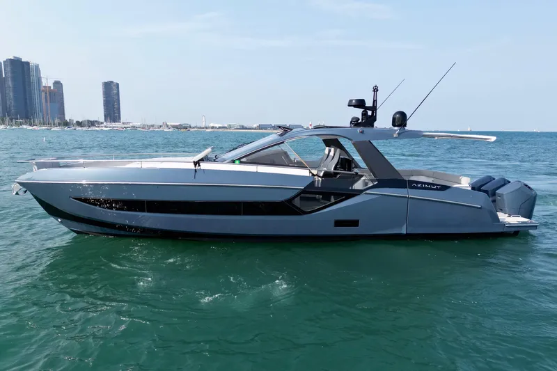  Yacht Photos Pics 2024 Azimut Verve 48 yacht cruising on open water with city skyline in background.