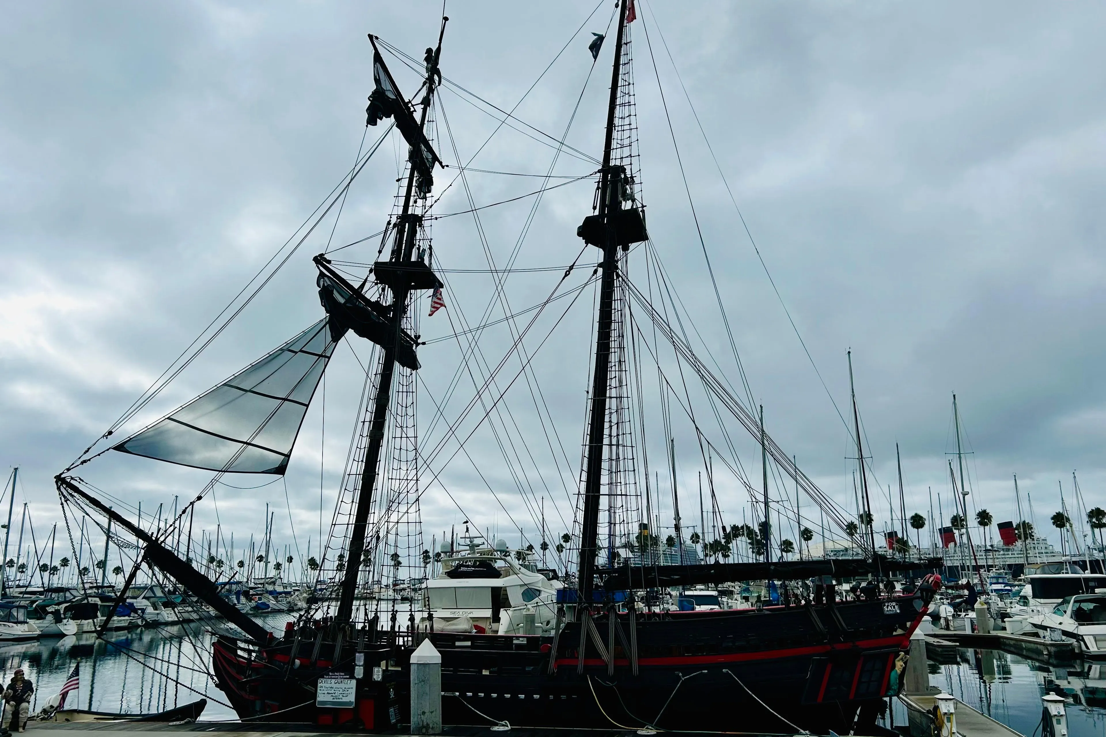 Vintage 1977 Custom Brigantine ship docked at a marina under cloudy skies.