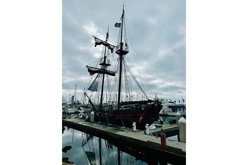 Devil's Gauntlet Yacht Photos Pics Vintage 1977 Custom Brigantine ship docked at marina under cloudy sky.