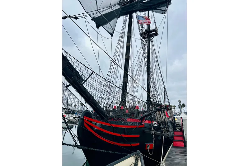 Devil's Gauntlet Yacht Photos Pics Vintage 1977 Custom Brigantine ship with red accents docked at a marina.