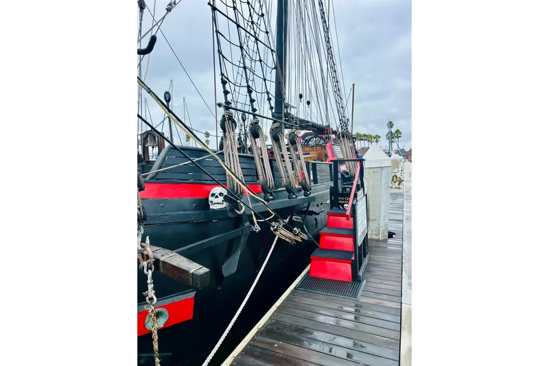 Devil's Gauntlet Yacht Photos Pics Vintage 1977 Custom Brigantine ship docked, featuring red accents and skull decoration.