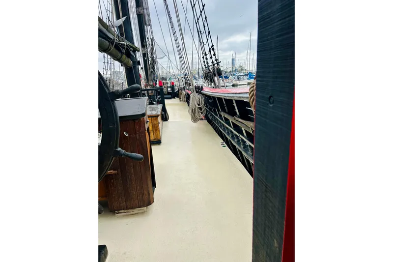 Devil's Gauntlet Yacht Photos Pics Deck view of a 1977 Custom Brigantine ship, showcasing rigging and wooden elements.