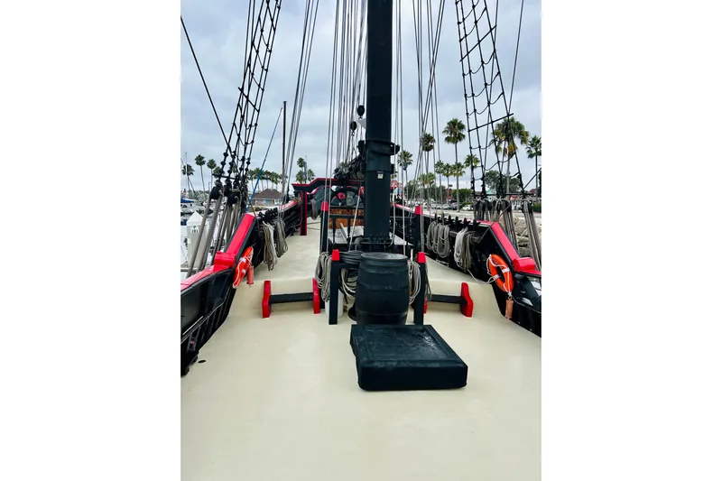 Devil's Gauntlet Yacht Photos Pics 1977 Custom Brigantine ship deck with ropes and rigging, docked near palm trees.