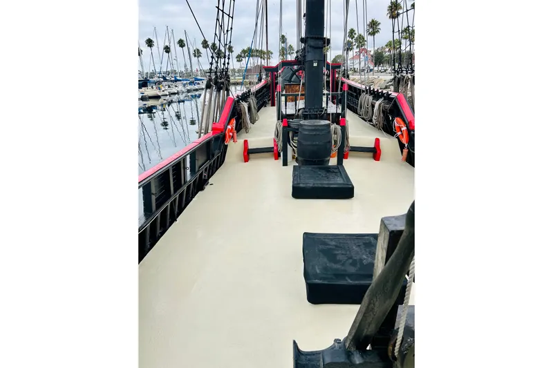 Devil's Gauntlet Yacht Photos Pics 1977 Custom Brigantine ship deck with ropes and lifebuoys, docked at a marina.