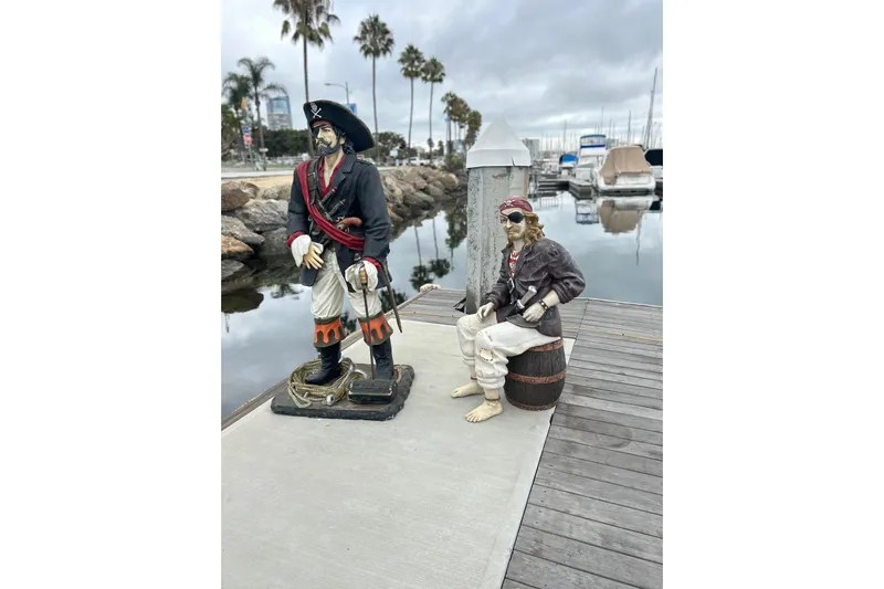 Devil's Gauntlet Yacht Photos Pics Pirate statues on dock with boats and palm trees in background, Custom Brigantine 1977.