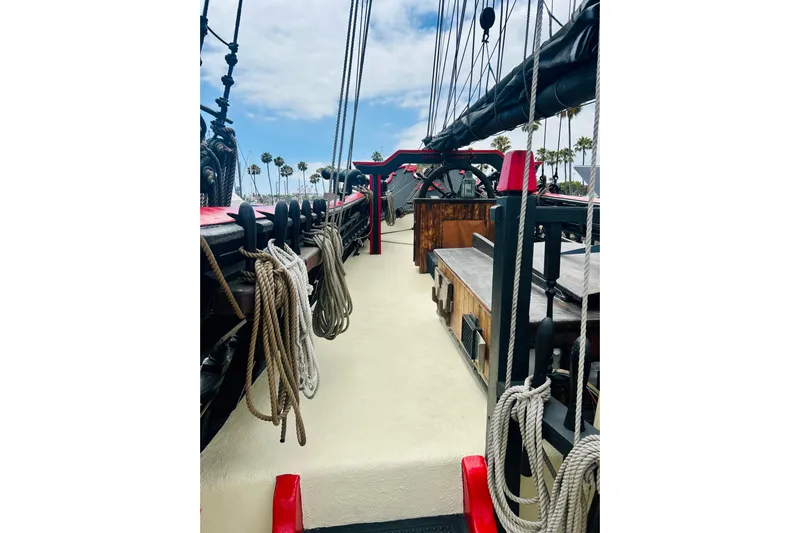 Devil's Gauntlet Yacht Photos Pics 1977 Custom Brigantine ship deck with ropes and rigging, under a partly cloudy sky.