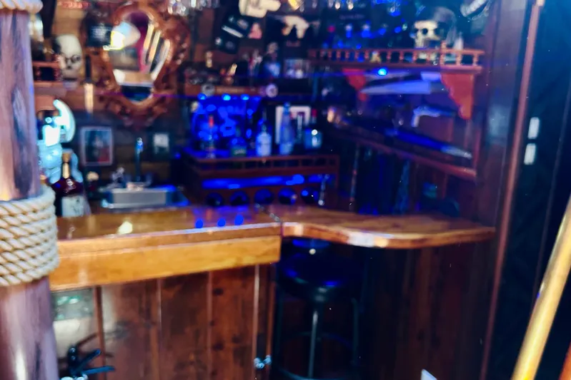 Devil's Gauntlet Yacht Photos Pics Rustic nautical-themed bar with wooden decor and blue lighting, featuring a 1977 Custom Brigantine style.