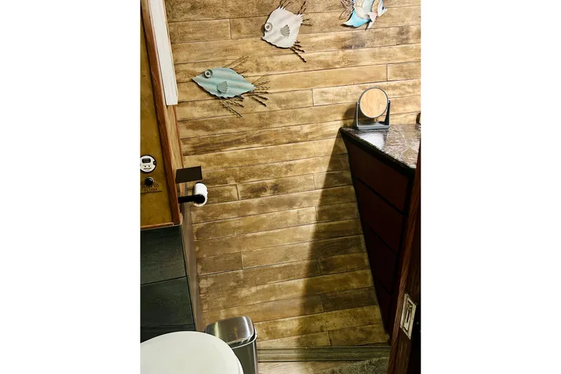 Devil's Gauntlet Yacht Photos Pics Wood-paneled bathroom with fish decor in a 1977 Custom Brigantine boat.