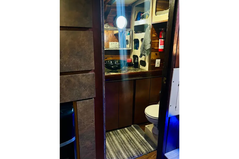 Devil's Gauntlet Yacht Photos Pics Interior of a 1977 Custom Brigantine boat bathroom with wooden accents and modern fixtures.