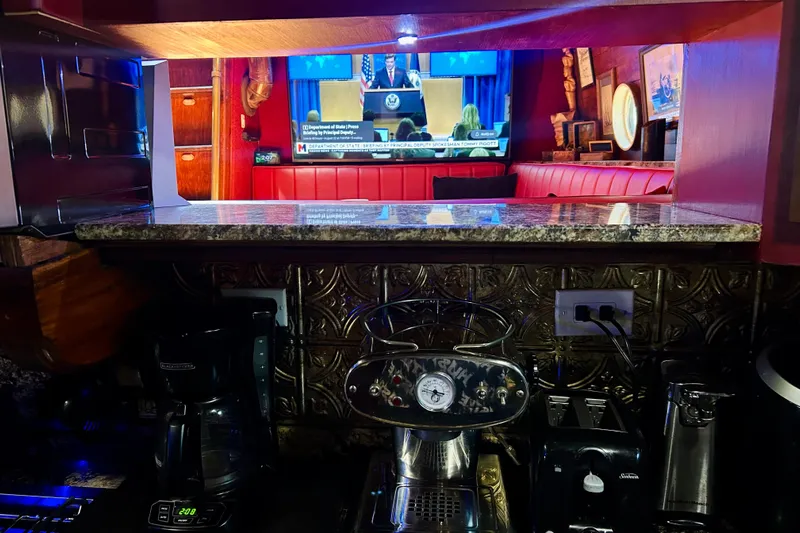 Devil's Gauntlet Yacht Photos Pics Cozy kitchen with coffee maker, granite countertop, and TV in a 1977 Custom Brigantine.