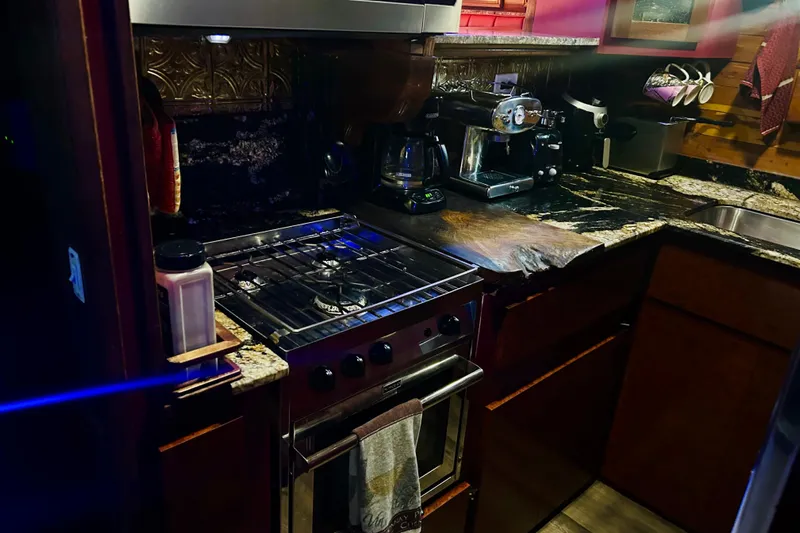 Devil's Gauntlet Yacht Photos Pics Cozy kitchen in a 1977 Custom Brigantine with stove, coffee maker, and granite countertops.