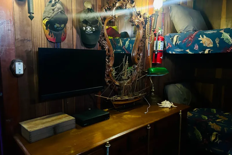 Devil's Gauntlet Yacht Photos Pics Cozy nautical-themed room with model ship, bunk beds, and vintage decor.