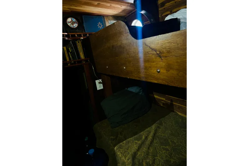 Devil's Gauntlet Yacht Photos Pics Cozy cabin interior of a 1977 Custom Brigantine with wooden bunk and bookshelves.