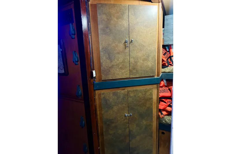 Devil's Gauntlet Yacht Photos Pics Wooden cabinets inside a 1977 Custom Brigantine boat, with life jackets stored nearby.