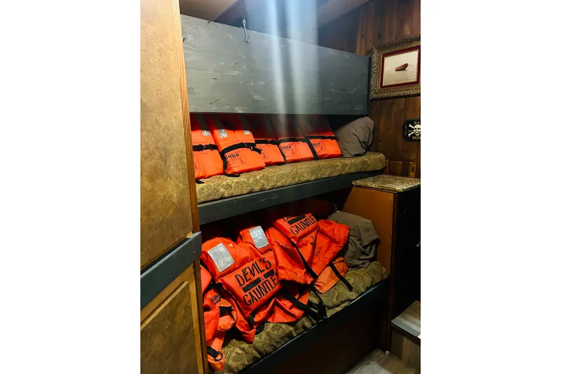 Devil's Gauntlet Yacht Photos Pics Bunk beds with orange life jackets labeled "Devil's Gauntlet" on a 1977 Custom Brigantine.