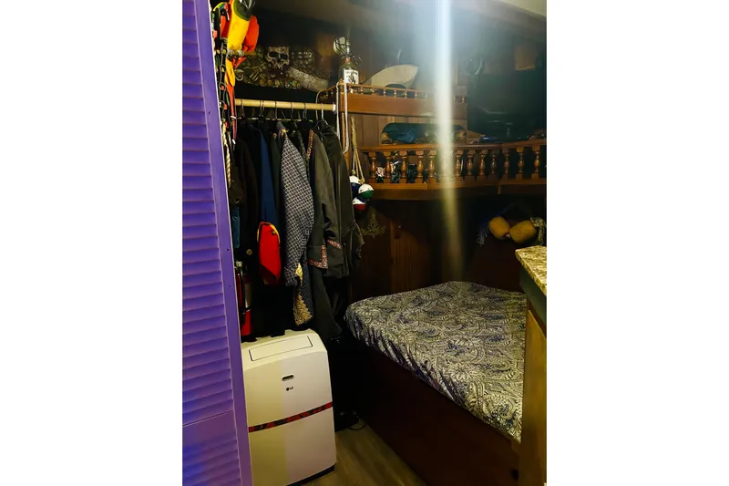 Devil's Gauntlet Yacht Photos Pics Cozy cabin interior of a 1977 Custom Brigantine with clothes, bed, and portable air conditioner.