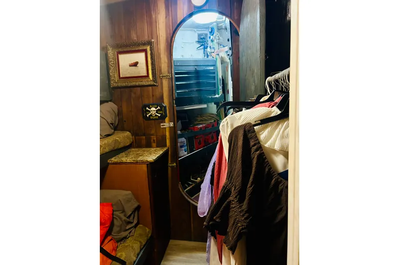 Devil's Gauntlet Yacht Photos Pics Interior of a 1977 Custom Brigantine with wooden walls, mirror, and hanging clothes.