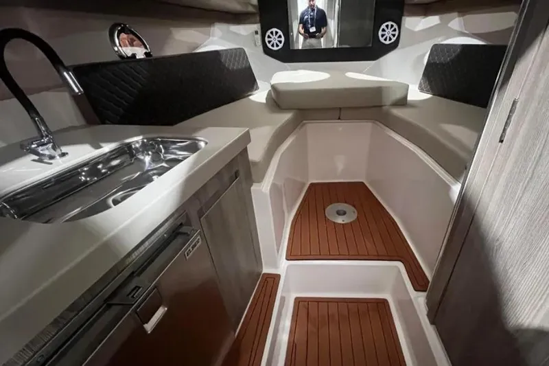 Ventura Yacht Photos Pics 2025 Ventura Daycruiser interior with modern kitchenette and seating area.