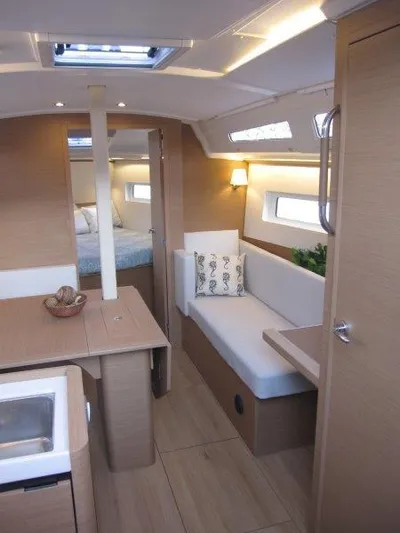  Yacht Photos Pics Modern interior of 2024 Jeanneau 380 sailboat with cozy seating and natural light.