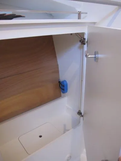  Yacht Photos Pics 2024 Jeanneau 380 interior storage compartment with wooden panel and white door.