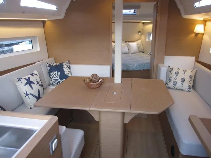  Yacht Photos Pics 2024 Jeanneau 380 yacht interior with dining area, cozy seating, and bedroom.