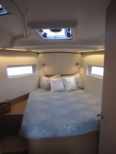  Yacht Photos Pics Luxurious cabin interior of 2024 Jeanneau 380 sailboat with cozy bed and natural light.