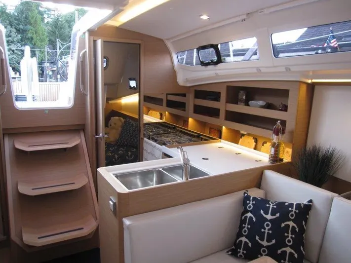  Yacht Photos Pics Interior of 2024 Jeanneau 380 sailboat with modern kitchen and cozy seating area.