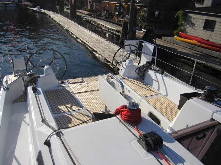  Yacht Photos Pics 2024 Jeanneau 380 sailboat docked, featuring dual steering wheels and teak deck.