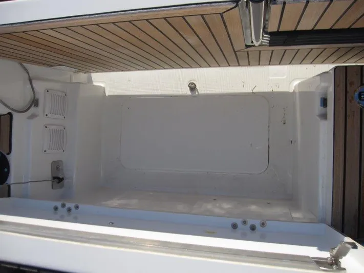  Yacht Photos Pics 2024 Jeanneau 380 boat interior with wooden deck and storage compartment.