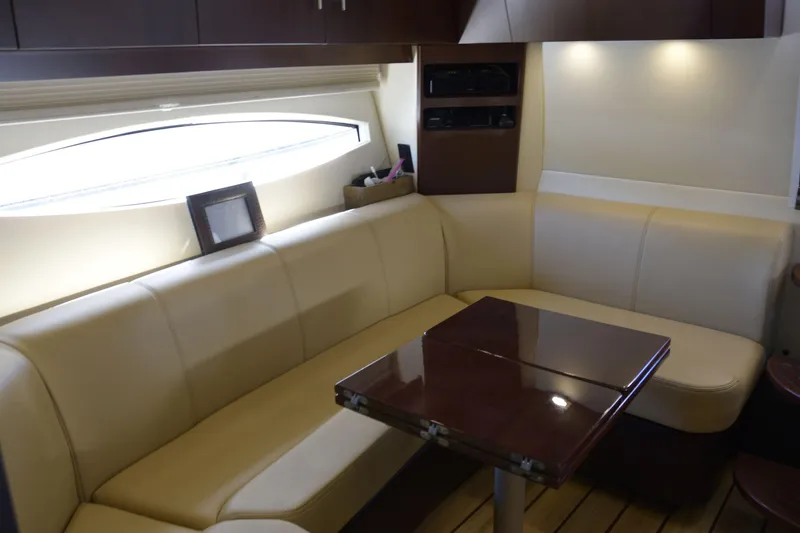  Yacht Photos Pics Luxurious interior of 2013 Regal 42 Sport Coupe with cream leather seating and wooden table.