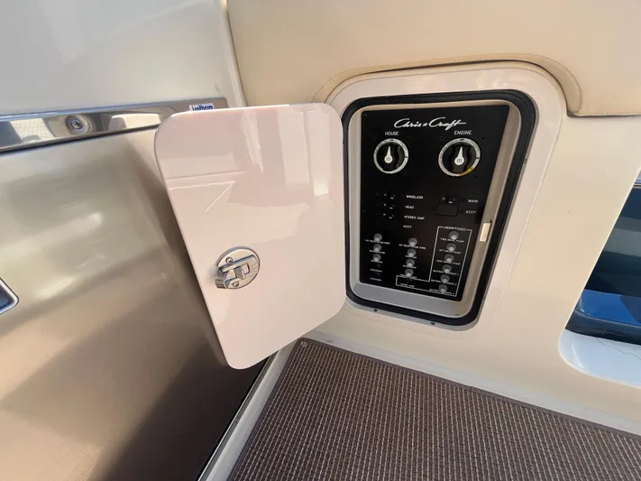  Yacht Photos Pics 2025 Chris-Craft Calypso 28 control panel with open access door, showcasing switches and dials.