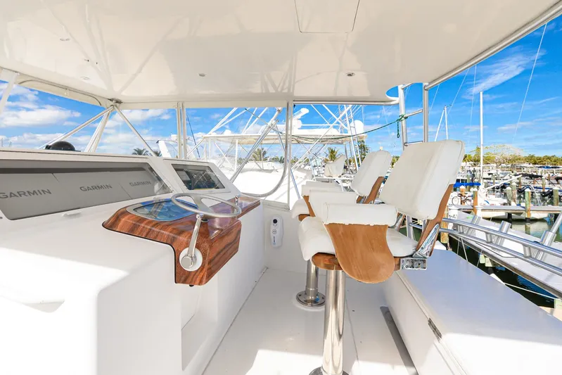Sue-sea Yacht Photos Pics Helm of 1999 Viking 55 Convertible yacht with white seating and navigation equipment.