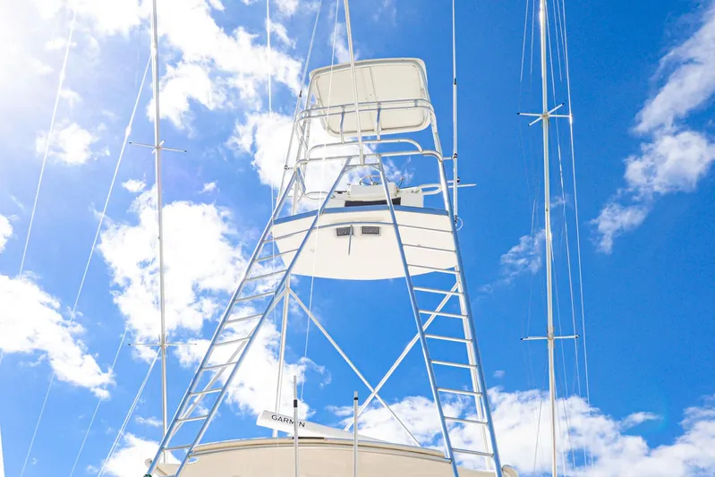 Sue-sea Yacht Photos Pics 1999 Viking 55 Convertible yacht tower against a bright blue sky with clouds.