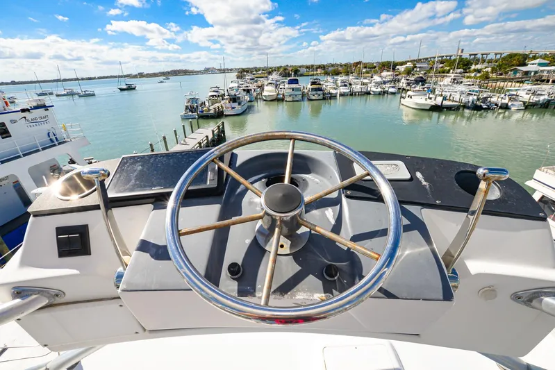 Sue-sea Yacht Photos Pics Steering wheel of 1999 Viking 55 Convertible yacht overlooking marina.