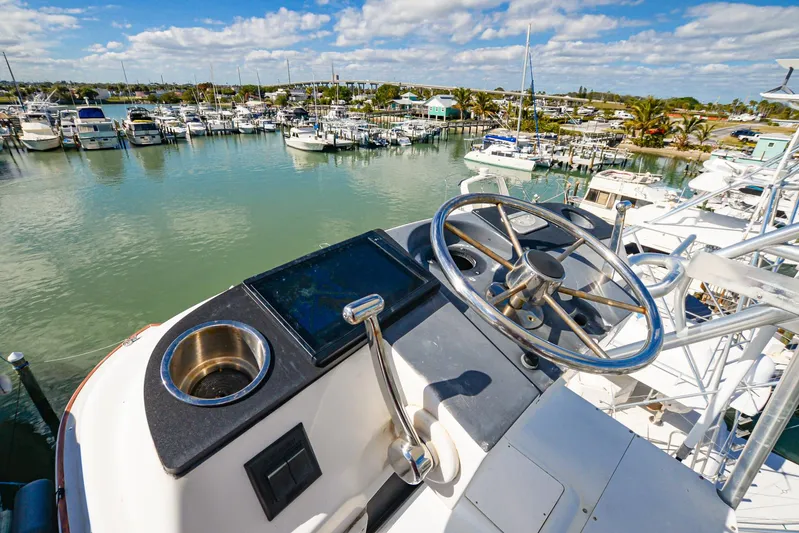 Sue-sea Yacht Photos Pics Helm of 1999 Viking 55 Convertible yacht overlooking marina with boats and clear sky.