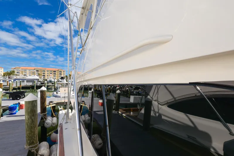Sue-sea Yacht Photos Pics 1999 Viking 55 Convertible yacht docked at marina under blue sky.