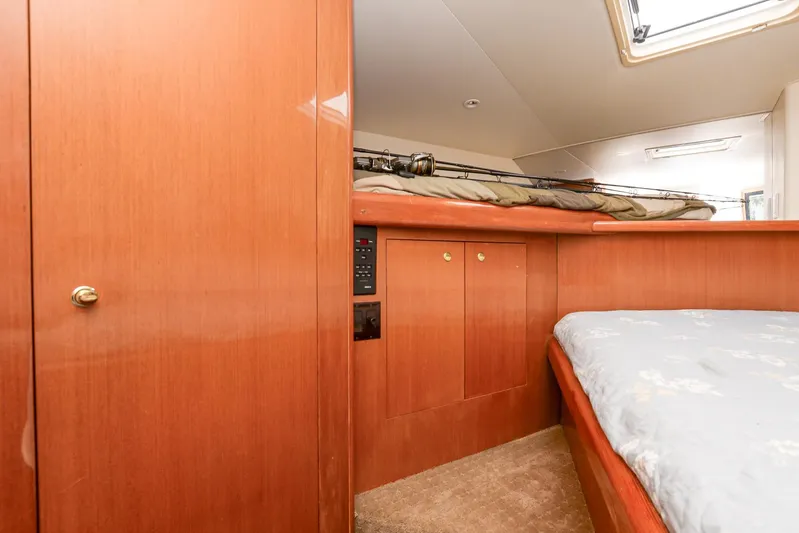 Sue-sea Yacht Photos Pics Interior cabin of 1999 Viking 55 Convertible yacht with wooden paneling and bed.