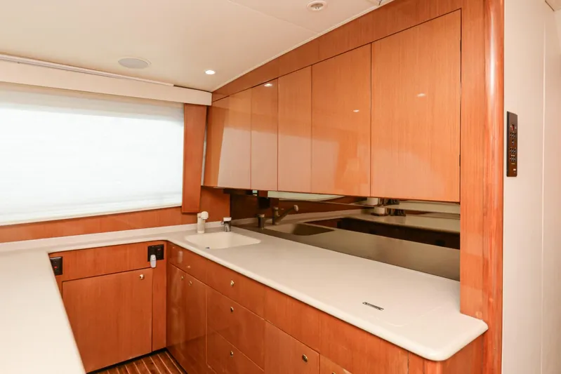 Sue-sea Yacht Photos Pics Luxurious kitchen interior of 1999 Viking 55 Convertible yacht with wooden cabinetry.