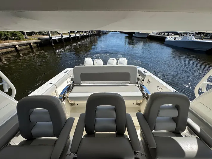  Yacht Photos Pics 2016 Boston Whaler 420 Outrage boat interior with seating, docked by a calm waterway.