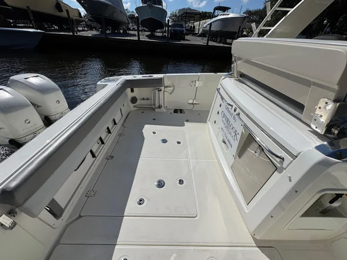  Yacht Photos Pics 2016 Boston Whaler 420 Outrage boat deck with seating and storage, docked by the water.