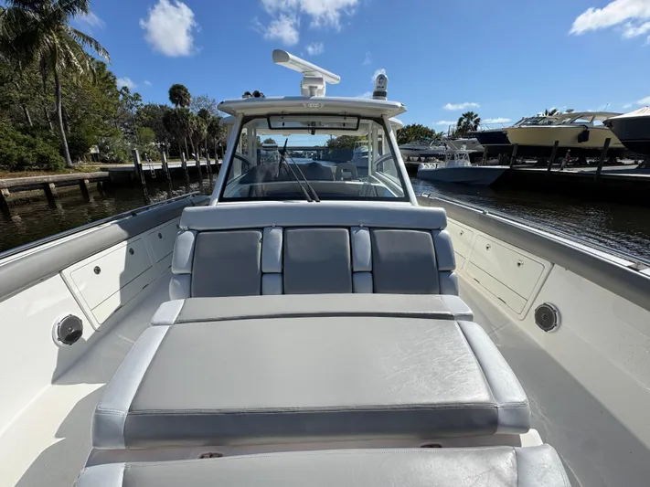  Yacht Photos Pics 2016 Boston Whaler 420 Outrage boat with spacious seating, docked under a clear blue sky.