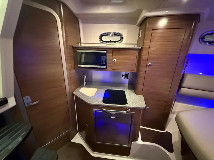  Yacht Photos Pics 2018 Boston Whaler 345 Conquest interior with kitchenette, featuring microwave, sink, and modern cabinetry.