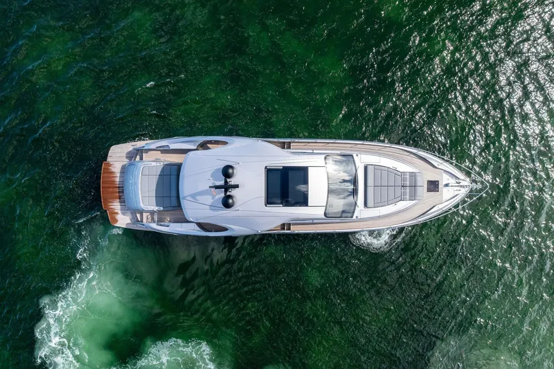 Niki Yacht Photos Pics Aerial view of 2024 Pershing 7X yacht cruising on green ocean waters.