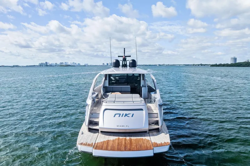 Niki Yacht Photos Pics 2024 Pershing 7X yacht on open water, rear view, clear sky, Miami skyline.