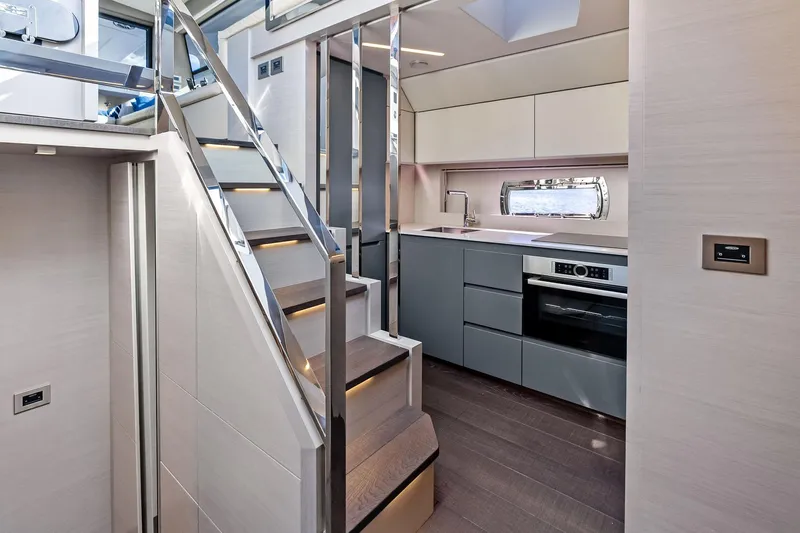 Niki Yacht Photos Pics Luxurious interior of 2024 Pershing 7X yacht featuring modern kitchen and sleek staircase design.