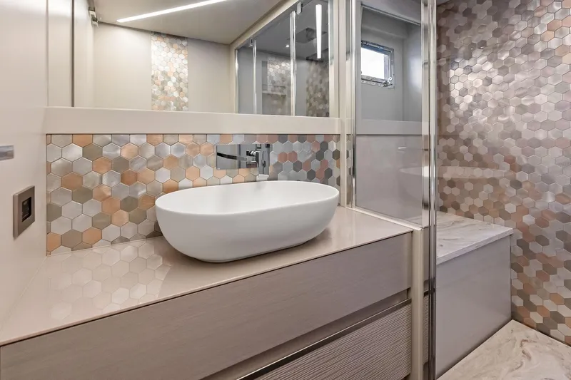 Niki Yacht Photos Pics Luxurious bathroom in 2024 Pershing 7X yacht with modern hexagonal tile design.