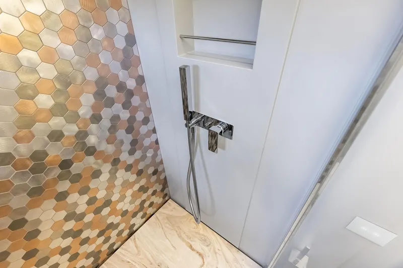 Niki Yacht Photos Pics Luxurious 2024 Pershing 7X yacht bathroom with hexagonal tiles and modern fixtures.