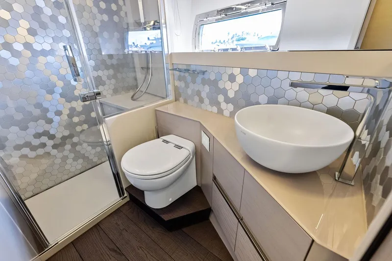Niki Yacht Photos Pics Luxurious 2024 Pershing 7X yacht bathroom with modern fixtures and hexagonal tile design.