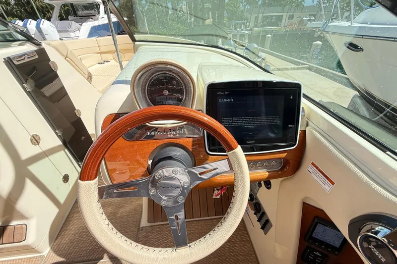 Yacht Photos Pics 2019 Chris-Craft Launch 28 GT dashboard with Garmin display and wooden steering wheel.